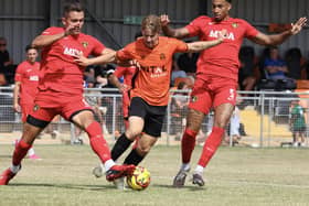Luca Miller (orange) in action for Peterborough Sports against Harborough Town.