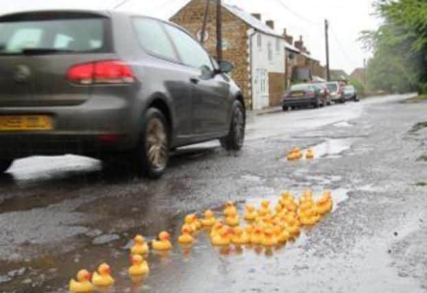 When the villagers of Steeple Aston, Oxfordshire, had a puddle duck party in the great road craters outside their local pub after accusing local officials of ducking the issue. (Photo credit  Twitter - @GrundyOxford)