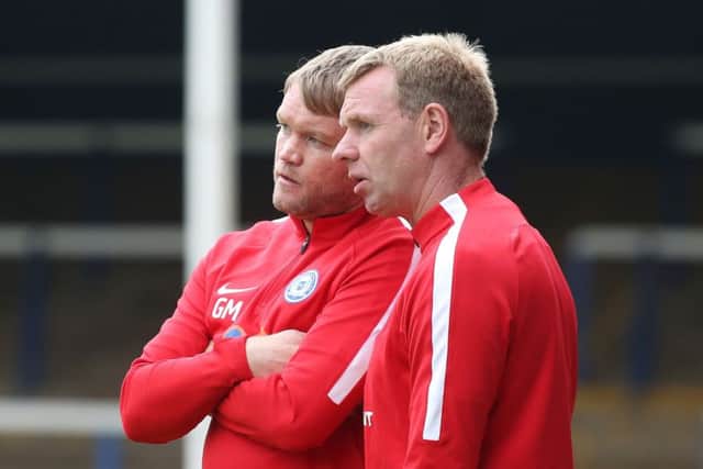 Posh assistant manager David Oldfield (near) with first-team boss Grant McCann.