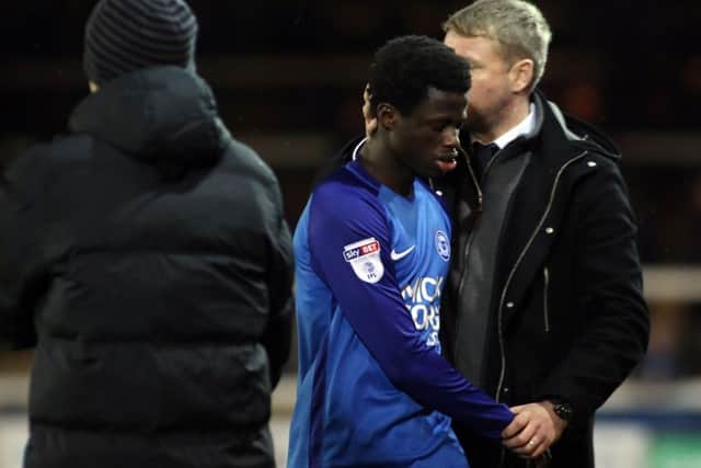 Posh teenager Leo Da Silva Lopes is consoled by manager Grant McCann.