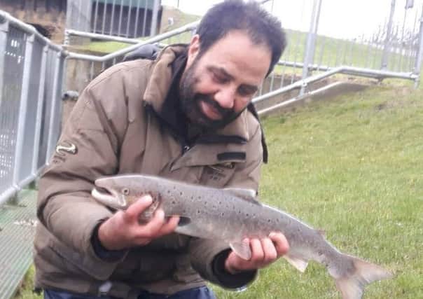 Afzal Din with his unusual catch from the Nene. Is it a sea trout or a salmon?