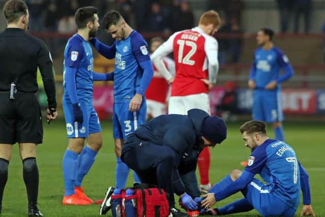 Posh midfielder Gwion Edwards is treated for the injury he picked up at Fleetwood.
