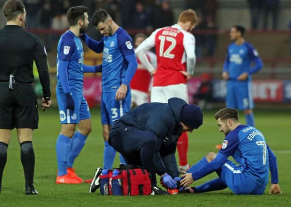 Posh midfielder Gwion Edwards is treated for the injury he picked up at Fleetwood.