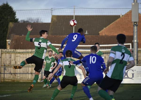 Avelino Vieira (blue) jumps highest for Peterborough Sports in their game against Lincoln United; Photo: James Richardson.