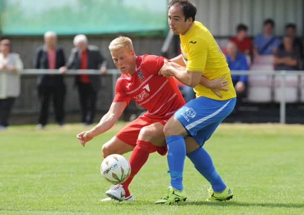 Michael Frew (red) scored twice for Wisbech against Holbeach.