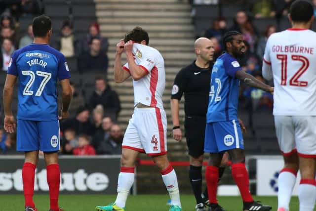 Mk Dons' defender Joe Walsh hides his face after his red card against Posh. Photo: Joe Dent/theposh.com.