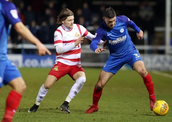 Posh left back Andrew Hughes in action against Alfie May of Doncaster. Photo: Joe Dent/theposh.com.