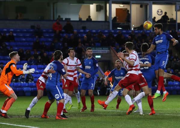 Ryan Tafazolli wins this header in the 1-1 draw with Doncaster. Photo: Joe Dent/theposh.com.