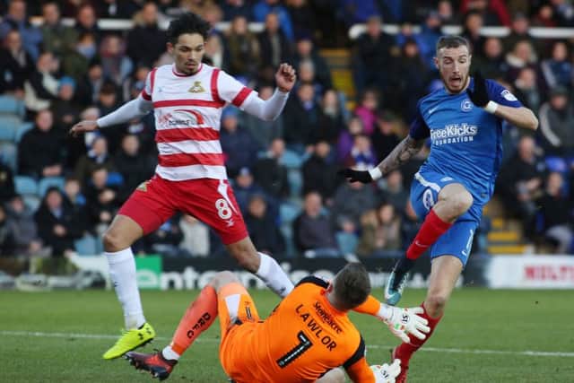 Posh star Marcus Maddison goes down under the challenge of Doncaster goalkeeper Ian Lawlor. Photo: Joe Dent/theposh.com.