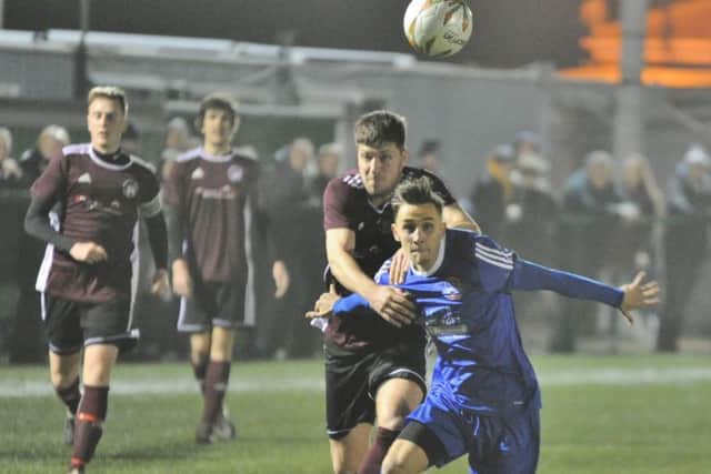 Matt Sparrow (blue) in action for Yaxley against Holbeach in a United Counties League Cup semi-final. Photo: David Lowndes.