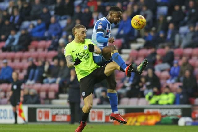 Posh star Marcus Maddison battles with Wigan's Gavin Massey. Photo: Joe Dent/theposh.com.