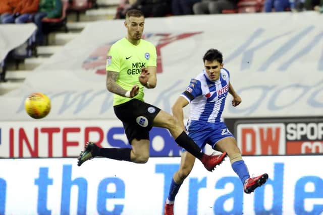 Posh star Marcus Maddison tries to cut out a cross from Wigan left back Reece James. Joe Dent/theposh.com.