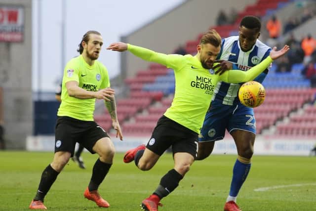 Posh winger Danny Lloyd tries to muscle his way past Wigan defender Chey Dunkley. Joe Dent/theposh.com.