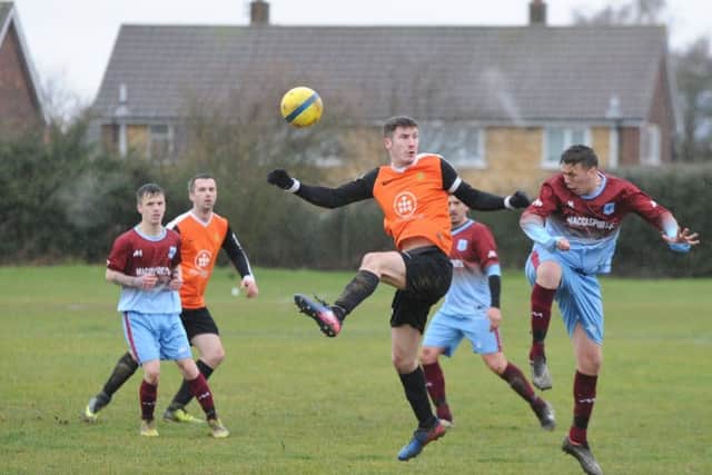 Harry Woodward (right) of Bretton North End challenges for a header against Stamford Bels. Photo: David Lowndes.