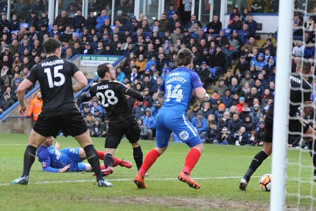 Posh defender Andrew Hughes (partially hidden) scores against Leicester. Photo: David Lowndes.
