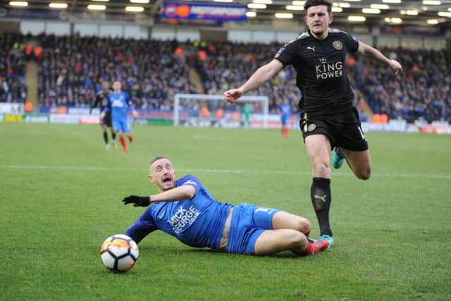 Posh forward Marcus Maddison is on the floor after a challenge from Leicester defender Harry Maguire. Photo: David Lowndes.