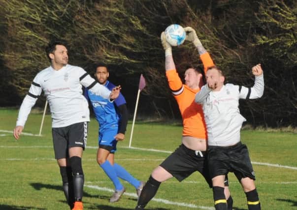 Ploughman goalkeeper Lea Jordan catches the ball under pressure from PIS forwards in a PFA Sunday Senior Cup tie.
