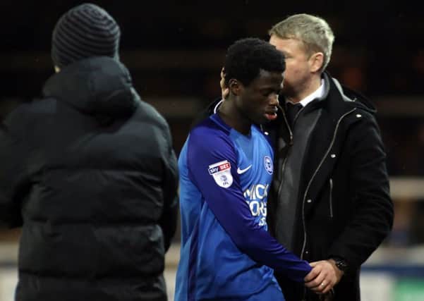 Posh teenager Leo Da Silva Lopes is consoled by manager Grant McCann after a substitution.