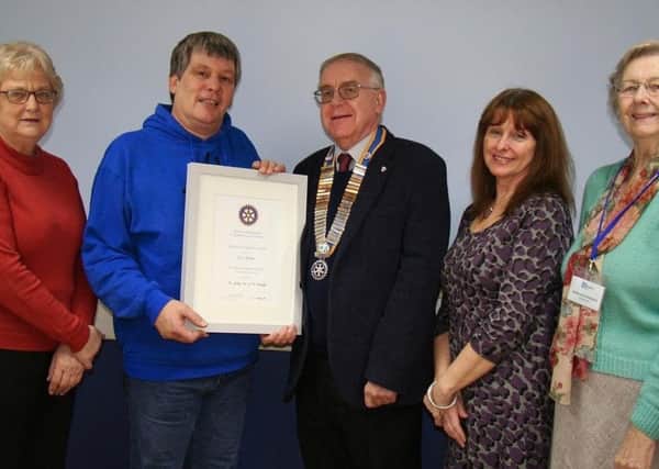 Jez Dubber receives his Service to the Community Award from Rotary
President Alan Kendrick, watched by, from left, Viv Gayle, Debbie Hedley and Joan  McCormack of the Community Centre