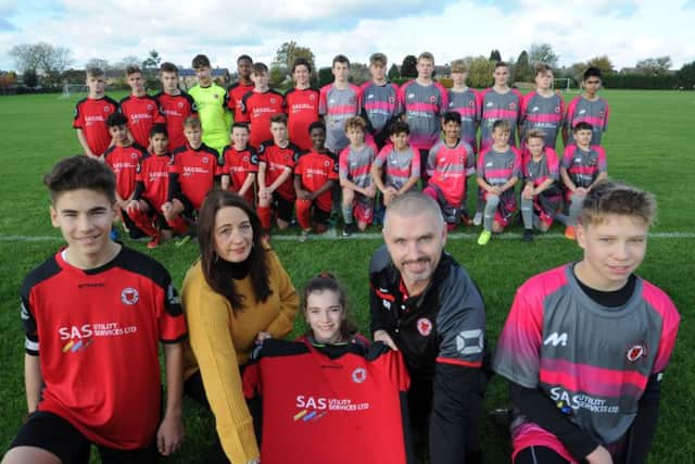 Netherton United Under 14 manager Simon Roberts, pictured here receiving sponsored kit from Debbie Isham of SAS Utility, will hopefully take one of his teams into the Junior Premier League next season.