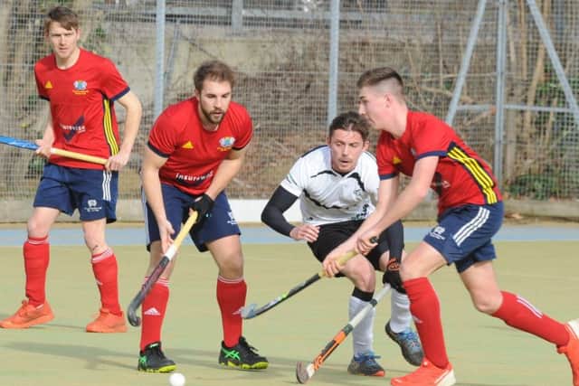 Brendan Andrews (red) moves onto the attack for City of Peterborough against Harleston, watched by teammate Joe Finding. Photo: David Lowndes.