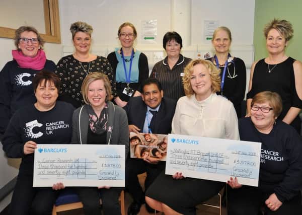 Ladies from Gratefully Uncovered, cancer sufferers who raised funds from a calender, presenting cheques to staff at Cancer Research UK and NW Anglia Breast Unit CF at the City Hospital EMN-180215-151436009