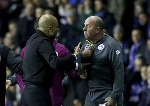 Manchester City manager Pep Guardiola (left) and Paul Cook (right) at loggerheads during a stormy FA Cup tie.