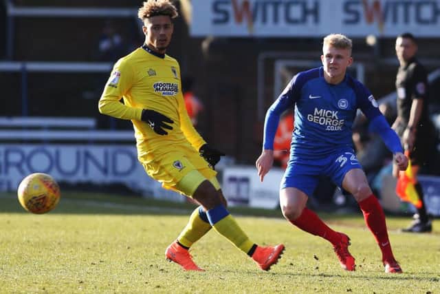 Posh left-back Lewis Freestone passes the ball past Wimbledon striker Lyle Taylor. Photo: Joe Dent/theposh.com.
