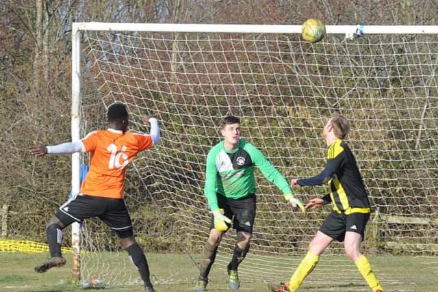 John Yambasu (orange) scores for Thorney against Holbeach United. Photo: David Lowndes.