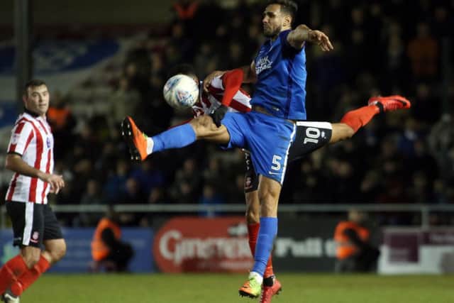Ryan Tafazolli in action for Posh against Lincoln City.