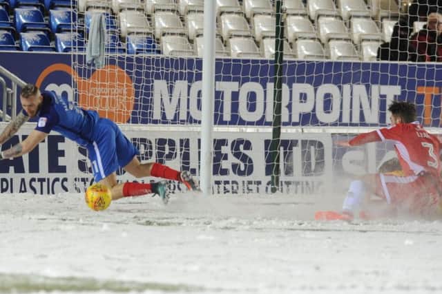 Posh star Marcus Maddison tumbles in the snow towards the end of the win over Walsall. Photo: David Lowndes.
