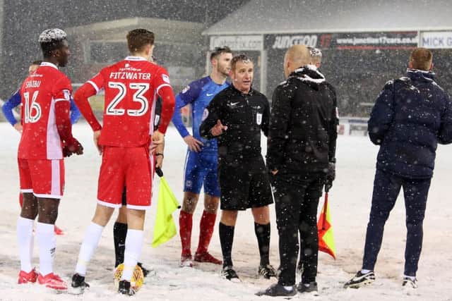 Referee Lee Swaby talks to Walsall manager Jon Whitney during a break in play in the game at Posh. Photo: Joe Dent/theposh.com.