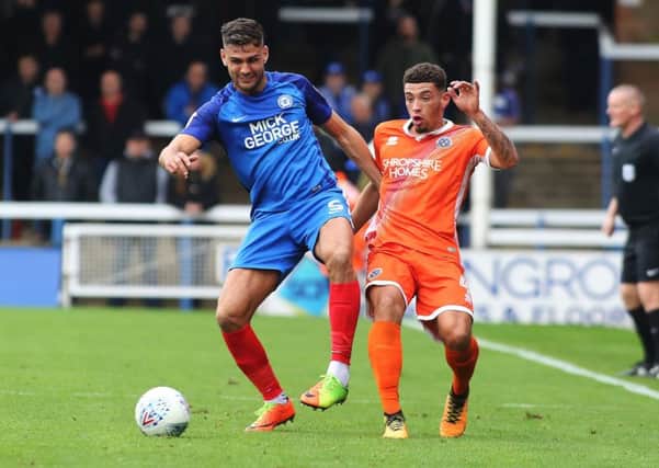 Ryan Tafazolli of Peterborough United in action with Ben Godfrey of Shrewsbury Town.