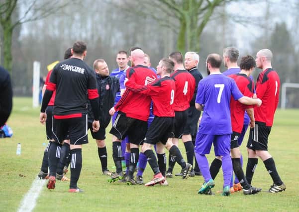 A flashpoint in the Northants Area Cup tie between NECI (purple) and Weldon United Reserves. Photo: David Lowndes.