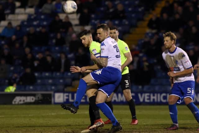 Posh skipper Jack Baldwin wins a header at Bury. Photo: Joe Dent/theposh.com.
