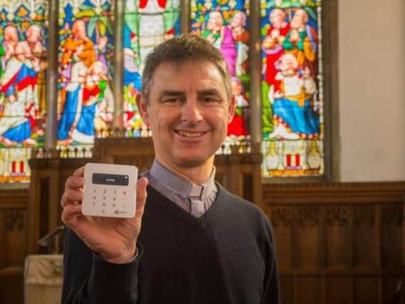 Martyn Taylor, Rector at St Georges Church, Stamford, Lincolnshire, holds a contactless payment device. (SumUp/PA)