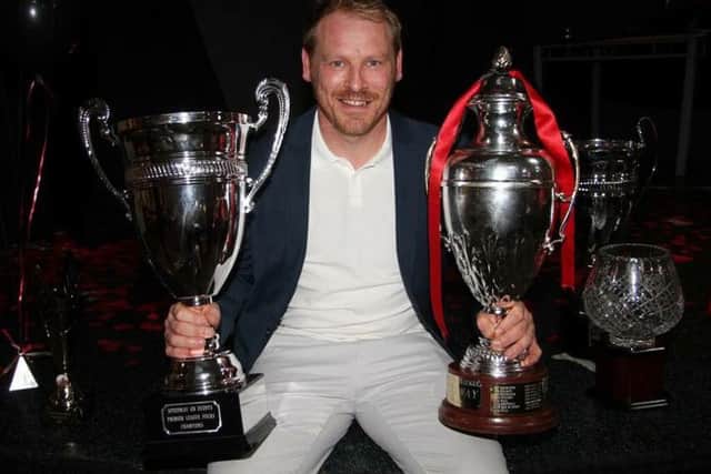 Carl Johnson with the two trophies Panthers won last year.
