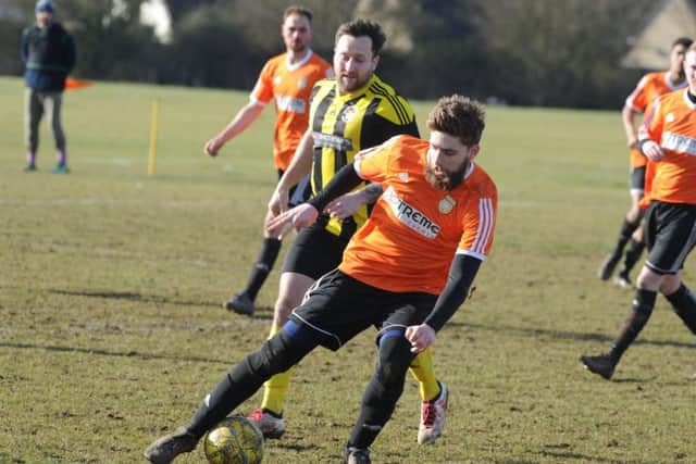 Thorney FC (orange) in action.