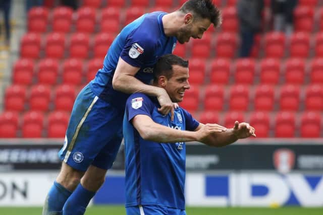 Andrew Hughes jumps on Posh teammate Steven Taylor in celebration after the draw at Rotherham United. Photo: Joe Dent/theposh.com.