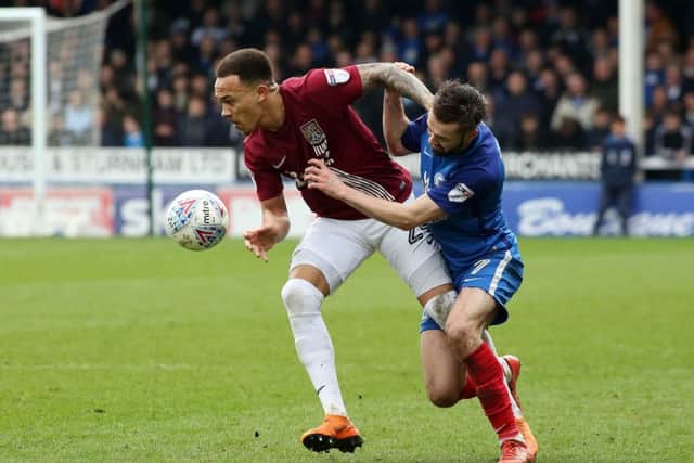 Returning Posh star Gwion Edwards battles for possession with Shay Facey of Cobblers. Photo: Joe Dent/theposh.com.