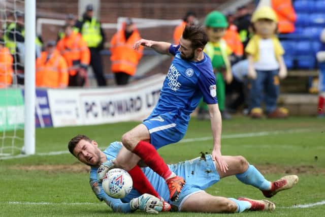 Gwion Edwards of Posh challenges Cobblers' keeper Richard O'Donnell. Photo: Joe Dent/theposh.com.