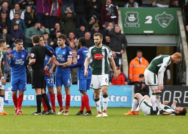Liam Shephard of of Peterborough United is shown a straight red card after a coming together with Graham Carey of Plymouth Argyle (floored). Picture: Joe Dent