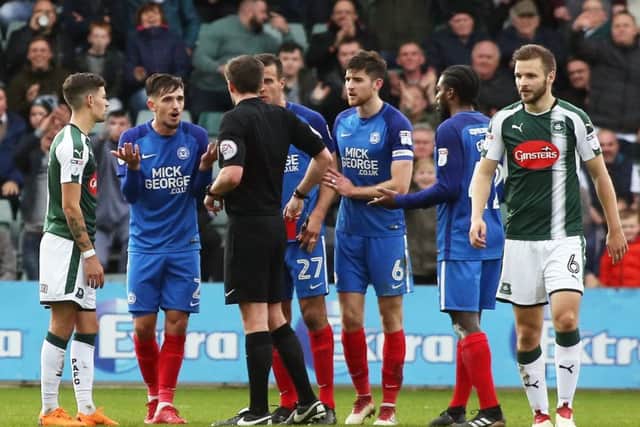 Liam Shephard of of Peterborough United is shown a straight red card after a coming together with Graham Carey of Plymouth Argyle. Picture: Joe Dent