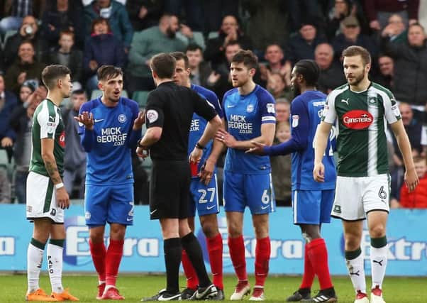 Liam Shephard of of Peterborough United is shown a straight red card after a coming together with Graham Carey of Plymouth Argyle. Picture: Joe Dent