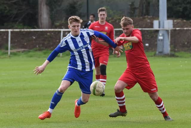 Jake Sansby (red) of Peterborough Northern Star in action at Eynesbury Rovers. Photo: Chantelle McDonald. @cmcdphotos.