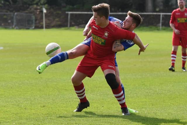 Harry Fitzjohn (red) of Peterborough Northern Star in action at Eynesbury Rovers. Photo: Chantelle McDonald. @cmcdphotos.