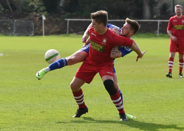 Harry Fitzjohn (red) of Peterborough Northern Star in action at Eynesbury Rovers. Photo: Chantelle McDonald. @cmcdphotos.