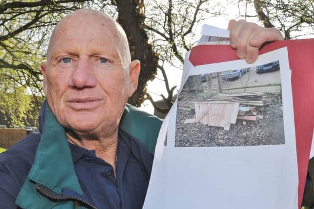 Alfie Green at the fence at Willonholt where the council say he fly-tipped wood. EMN-180414-183715009