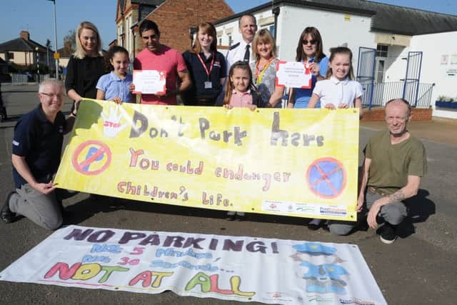 Peter Melkowski and Heather Phillips from Print Solutions with PC Jon Morris , parents, staff and pupils at the Discovery Primary School who have designed their own parking signs. EMN-180420-155431009