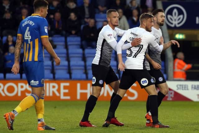 Posh star Gwion Edwards (centre) is congratulated after opening the scoring at Shrewsbury. Photo: Joe Dent/theposh.com.